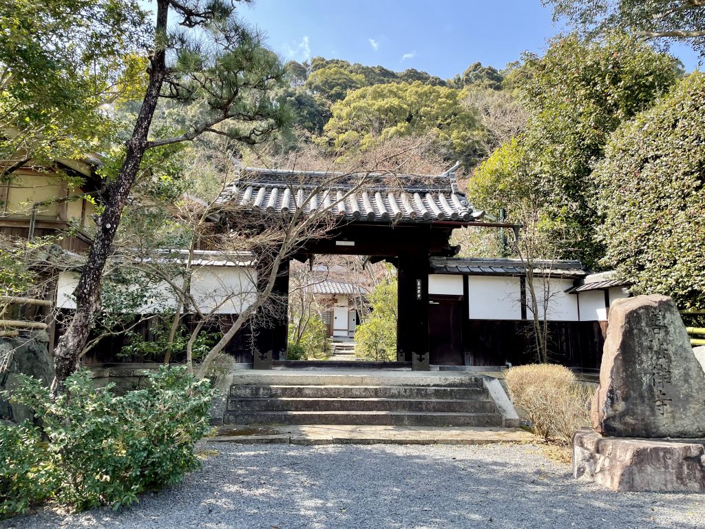 At a quiet temple, appreciate the beauty of maple leaves and the old Buddhist statues in the main hall.